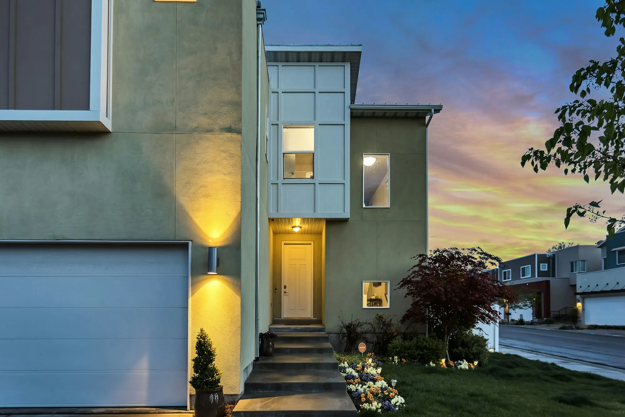 Home with a lit doorway under a colorful sky