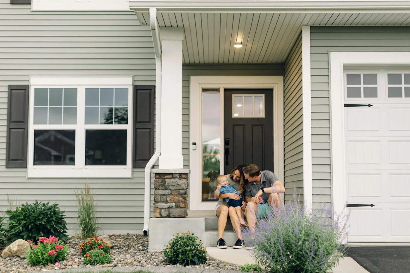 Family sitting on the front steps of their home